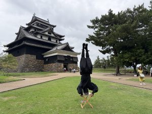 本丸広場で逆立ちをする黒装束の人